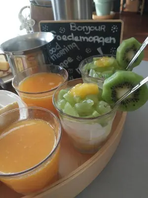 a tray with bowls of fruit and juice on a table at B&Bslapenopeeneiland in Kaag