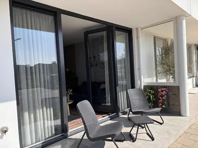 two chairs sitting on a patio in front of a house at Strand en meer in Katwijk aan Zee