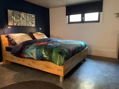 a bedroom with a bed with a colorful comforter at Strand en meer in Katwijk aan Zee