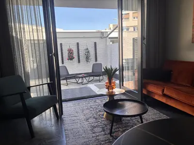 a living room with a couch and a balcony at Strand en meer in Katwijk aan Zee