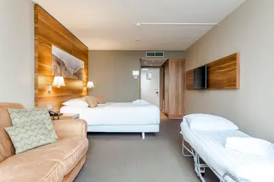 a hotel room with two beds and a couch at Suite with stunning sea view in Zandvoort