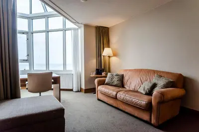 a living room with a couch and a large window at Suite with stunning sea view in Zandvoort