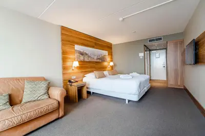 a hotel room with a bed and a couch at Suite with stunning sea view in Zandvoort