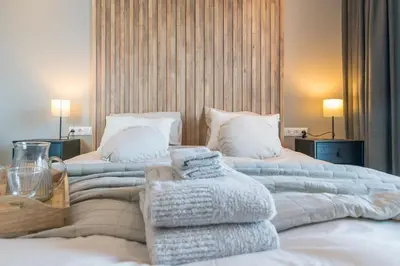 a bedroom with two beds with towels on them at Luxe appartement dichtbij strand en zee, in het hart van de bollenstreek in Noordwijkerhout
