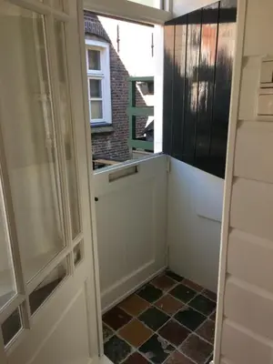 a door leading into a kitchen with a tiled floor at Family fisherman's house Volendam in Volendam