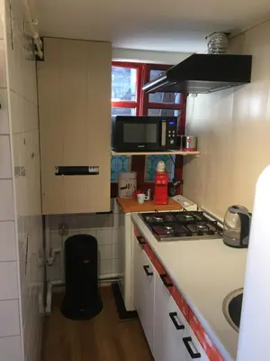 a small kitchen with a stove and a microwave at Family fisherman's house Volendam in Volendam