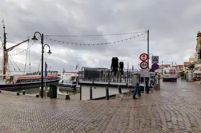 a dock with a pier with boats in the water at Family fisherman's house Volendam in Volendam