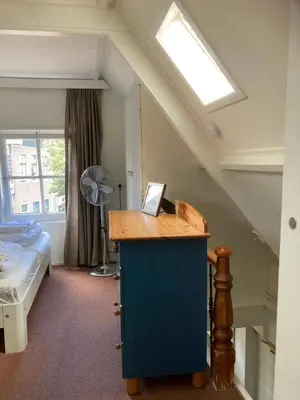 a room with a bed and a desk with a window at Family fisherman's house Volendam in Volendam