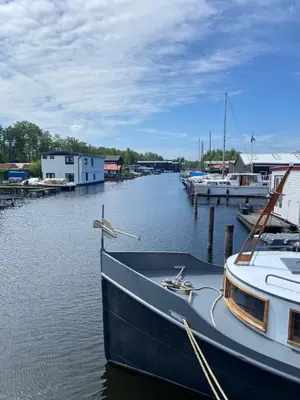 a boat is docked at a dock in the water at Tjotter in Amsterdam