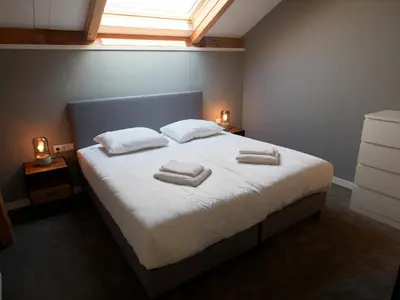 a bedroom with a bed with two towels on it at Dutchen Erfgoedpark De Hoop Vakantiewoningen in Uitgeest