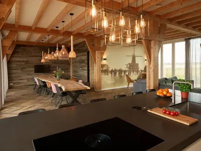 a kitchen and dining room with a large black counter top at Dutchen Erfgoedpark De Hoop Vakantiewoningen in Uitgeest