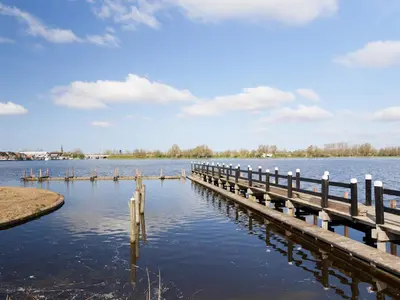 a dock on a body of water at Dutchen Erfgoedpark De Hoop Vakantiewoningen in Uitgeest