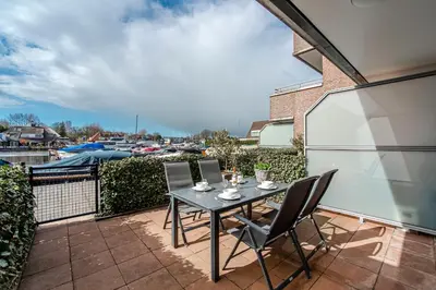 a patio with a table and chairs on a balcony at Kaag Resort in Warmond