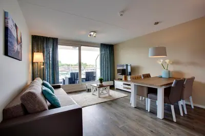 a living room with a couch and a dining room table at Kaag Resort in Warmond