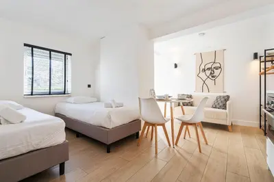 a bedroom with two beds and a table and chairs at Studio Thor, With free parking in Zandvoort