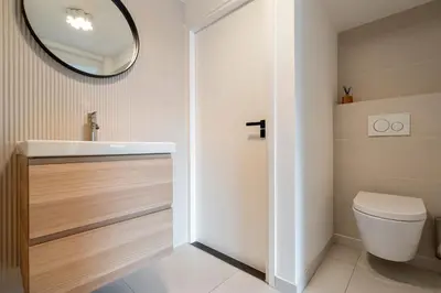 a bathroom with a toilet and a mirror at Studio Thor, With free parking in Zandvoort