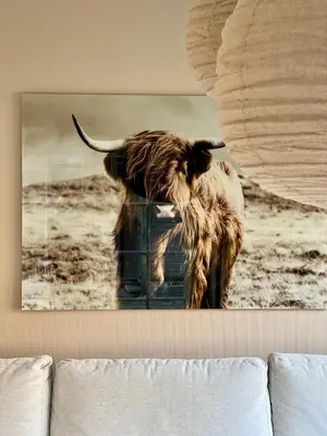a cow hanging on a wall above a couch at De Kroft Beach Residences Noordwijk aan Zee in Noordwijk