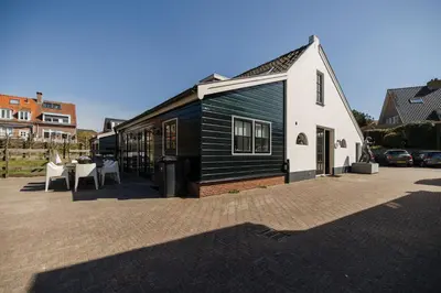 a black and white building with a table and chairs at De Kroft Beach Residences Noordwijk aan Zee in Noordwijk