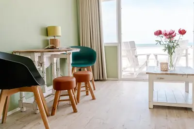 a room with chairs and a table and a window at Rijk aan Zee Ecolodges in Wijk aan Zee