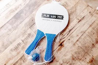 a tennis racket in a plastic bag on a wooden table at Rijk aan Zee Ecolodges in Wijk aan Zee