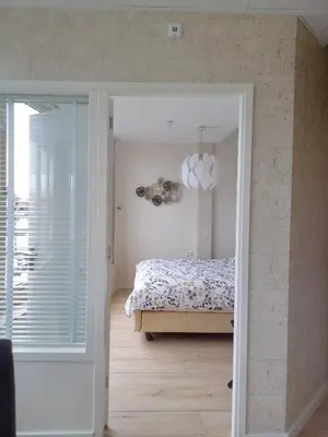 a bedroom with a bed and a room with a window at Pura Vida del Rio in Oud-Ade
