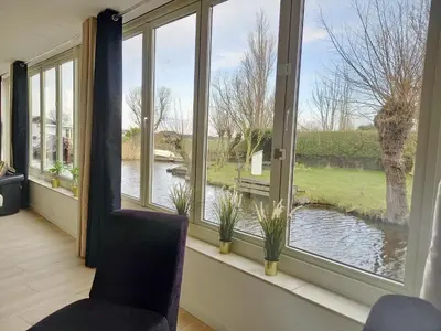 a room with a window with a view of a river at Pura Vida del Rio in Oud-Ade