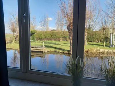 a window with a view of a pond outside at Pura Vida del Rio in Oud-Ade