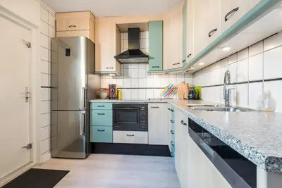 a kitchen with white cabinets and blue appliances at De Zonnestraal in Bergen