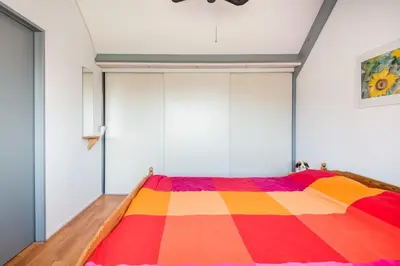 a bedroom with a bed with a colorful blanket at De Zonnestraal in Bergen