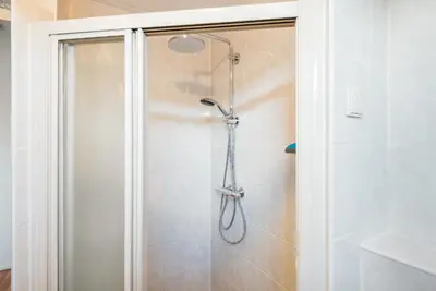 a shower with a shower head in a bathroom at De Zonnestraal in Bergen