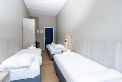 a row of three beds in a room at The Crown Hotel in Amsterdam