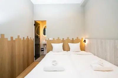 a bedroom with a large white bed with two white towels at The Crown Hotel in Amsterdam