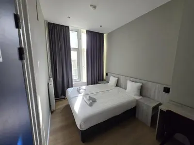 a hotel room with a bed and a window at The Crown Hotel in Amsterdam
