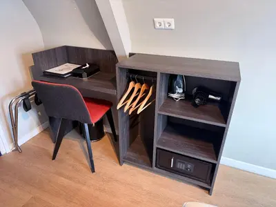 a desk in a room with a chair and a table at The Crown Hotel in Amsterdam