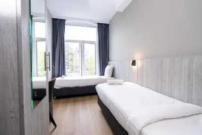a hotel room with two beds and a window at The Crown Hotel in Amsterdam