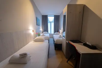 a row of beds in a hotel room at The Crown Hotel in Amsterdam