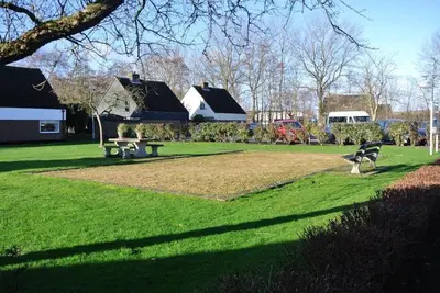 a park with two benches in the grass at Zeelicht in Noordwijkerhout