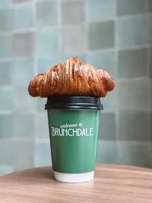 a coffee cup with a croissant on top of it at Bens The Highdocks in Amsterdam