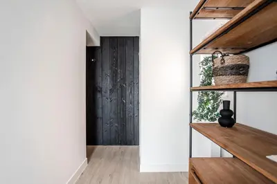 a hallway with white walls and wood floors at Marley’s Beachhouse - Luxury Apartment with garden in Zandvoort