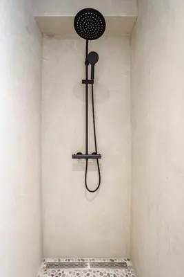 a shower in a bathroom with a shower head at Marley’s Beachhouse - Luxury Apartment with garden in Zandvoort