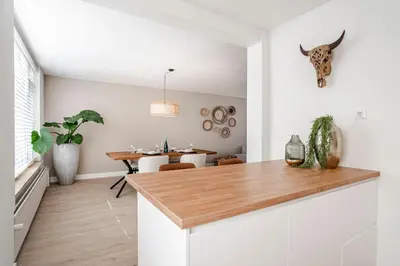 a kitchen with white walls and a wooden counter top at Marley’s Beachhouse - Luxury Apartment with garden in Zandvoort