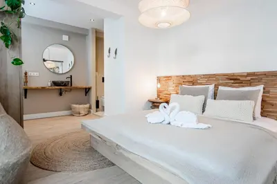 a bedroom with a large white bed with towels on it at Marley’s Beachhouse - Luxury Apartment with garden in Zandvoort