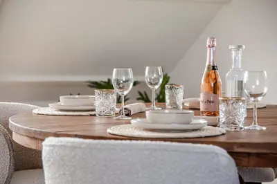 a wooden table with a bottle of wine and glasses at Yucca Beachhouse in Zandvoort