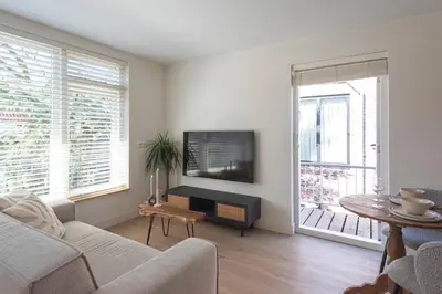 a living room with a couch and a tv at Yucca Beachhouse in Zandvoort