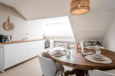 a kitchen and dining room with a wooden table and chairs at Yucca Beachhouse in Zandvoort
