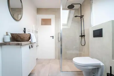 a bathroom with a shower and a toilet and a sink at Yucca Beachhouse in Zandvoort
