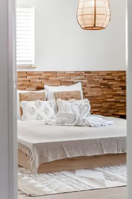 a bed with white blankets and pillows on it at Marley’s Beachhouse - Luxury Guest Room with balcony in Zandvoort