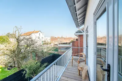 a balcony with a chair and a window at Marley’s Beachhouse - Luxury Guest Room with balcony in Zandvoort