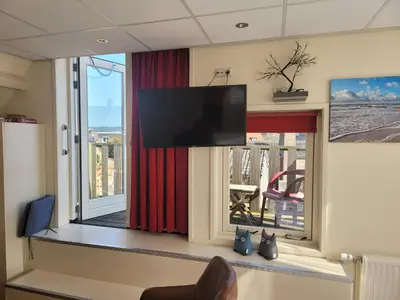 a room with a flat screen tv on a window at pension canberra in Bergen aan Zee
