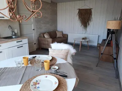 a living room with a table with plates on it at Wellness Lodge aan de Braassem in Rijnsaterwoude
